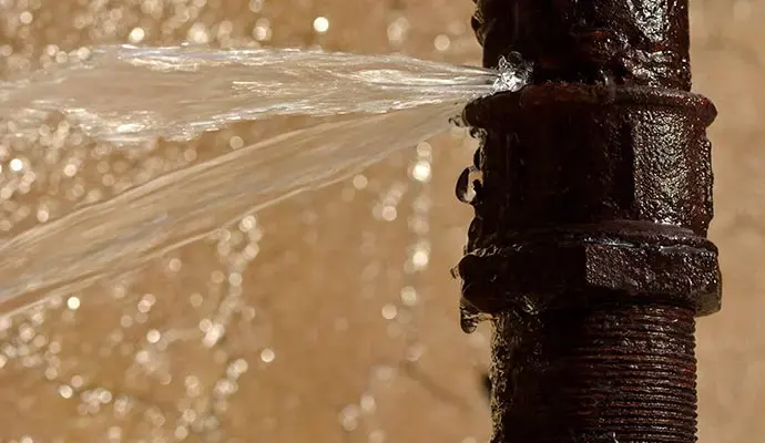 Water spraying from a split supply pipe during a Carrollton burst pipe loss