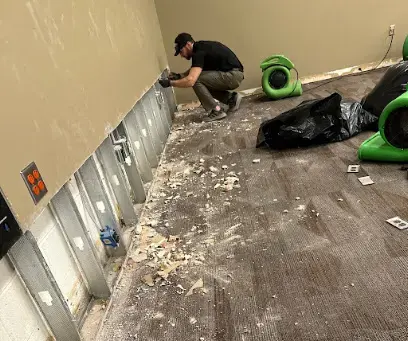 Drywall cut at the flood line with air movers drying the wall cavities